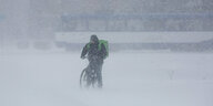 Das Foto zeigt einen Radahrer im dichten Schneetreiben.