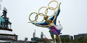 Glänzende Eisläufer-Figur mit Olympischen Ringen im Shougang-Park in Peking