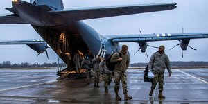 Britische und US-amerikanische Soldaten steigen aus einem Flugzeug