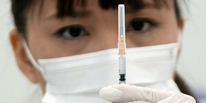 Eine medizinische Mitarbeiterin hält in einem Impfzentrum im Tokio Skytree eine Spritze mit einer Dosis des Corona-Impfstoffes von Moderna in der Hand.