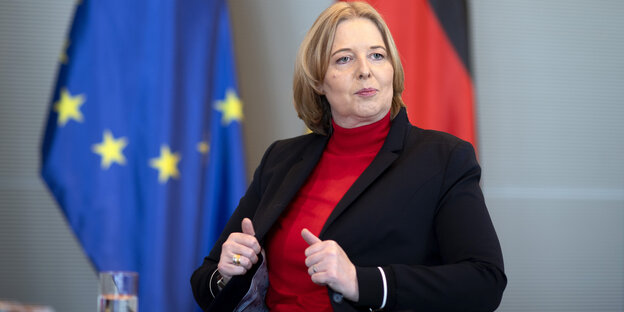 Bärbel Bas sitzt vor Europafahne und Deutschlandfahne