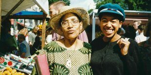 Die Schwarzen Autorinnen und Aktivistinnen Audre Lorde und May Ayim vor Verkaufsständen auf dem Winterfeldplatz in Berlin-Schöneberg im Jahr 1992