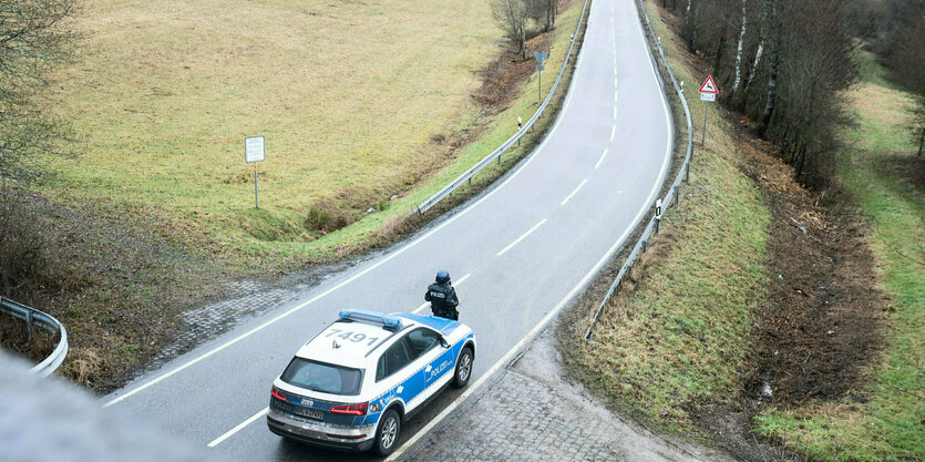 Ein Polizeiwagen steht auf einer Landstraße