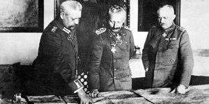 Bild in schwarz-weiß mit Kaiser Wilhelm II und zwei verbündeten über eine Karte gebeugt.