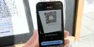 Ein Handy wird vor einen QR-Code gehalten