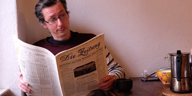 Ein Mann liest eine Zeitung