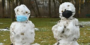 Zwei Schneemänner mit Masken