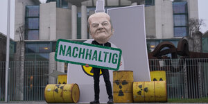 Aktivist mit Scholzmaske, Atommüllfässern und Schild "nachhaltig"