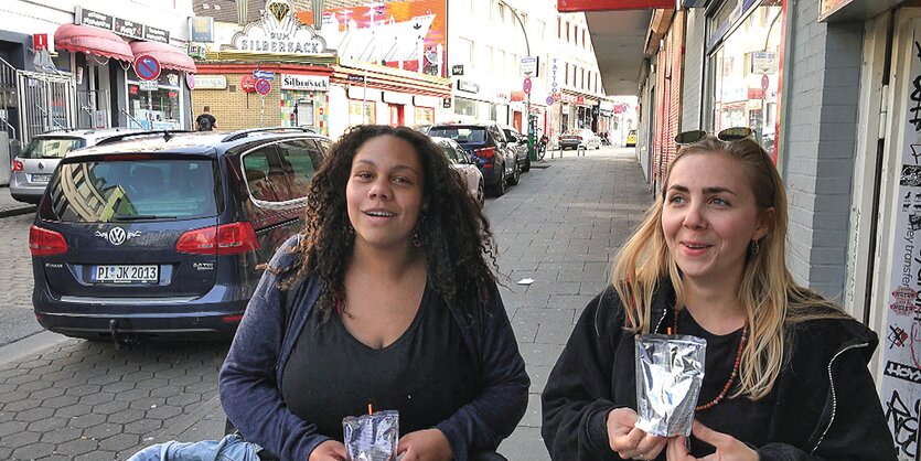 Zwei junge Frauen auf der Straße, im Hintergrund ist das Lokal "Zum Silbersack".