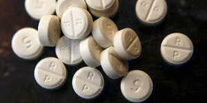 Weiße Pillen vor schwarzem Hintergrund