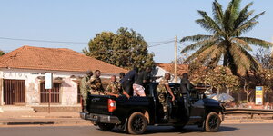 Bewaffnete Soldaten stehen auf einem Pickup