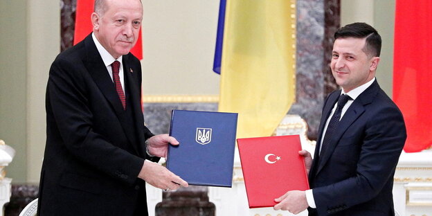 Wolodymyr Selenski und Tayyip Erdogan halten gemeinsam unterzeichnete Dokumente in die Kamera