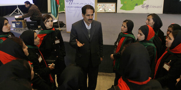 Ein Mann steht im Gespräch mit afghanischen Frauen