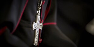 Großaufnahme von einem Kreuz-Kettenanhänger auf einem PRiestergewand