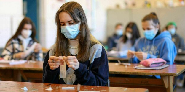 Eine Schülerin mit Mundnasenschutz macht in der Schule einen Schnelltest