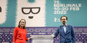 Zwei Menschen stehen vor einem Plakat der Berlinale