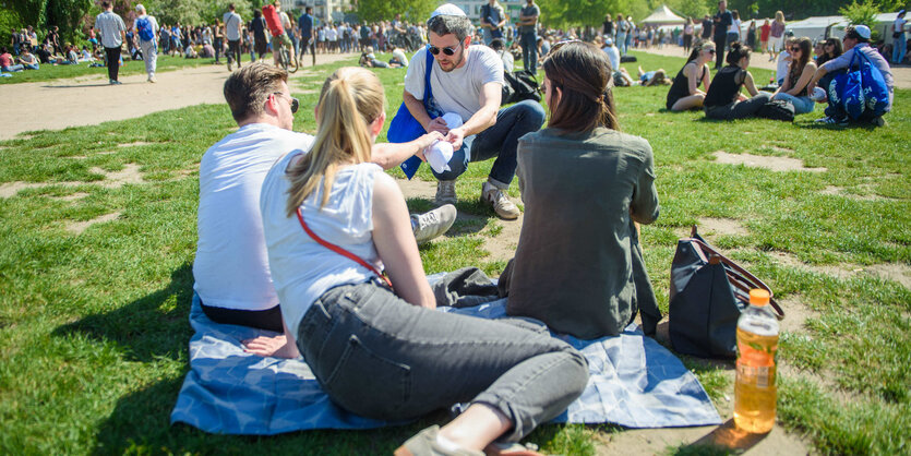 Eine Gruppe sitzt im Berliner Mauerpark