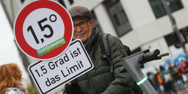 Mann auf Demonstration mit Schild "1,5 Grad ist das Limit"
