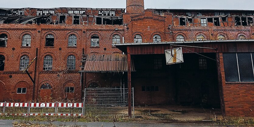 Ein verfallener Bau aus roten Ziegelsteinen.