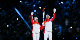 Eröffnungsfeier im Olympiastadion «Vogelnest». Die beiden Fackelläufer, die uigurische Langläuferin im chinesischen Team, Dinigeer Yilamujiang (l), und der Nordische Kombinierer Zhao Jiawen, stehen mit der Olympischen Fackel bei der Eröffnungsfeier der Ol