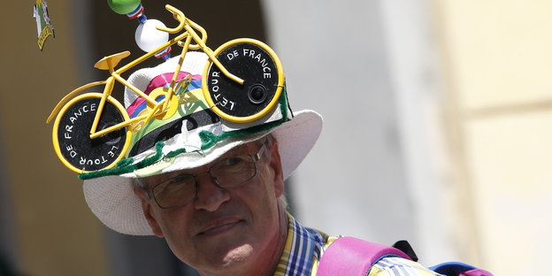 Tour-de-France-Fan mit gelbem Rennrad auf dem Panama-Hut