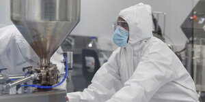 Ein Mensch in einem Labor mit weißer Laborkleidung