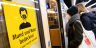 Zwei Frauen mit FFP2-Masken steigen in einer U-Bahnstation in die Bahn.