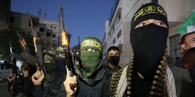 Männer mit schwarzen Gesichtsmasken und Gewehren im Anschlag