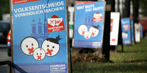 Hintereinanderstehende Plakate zum Volksentscheid "Volksentscheide verbindlich machen"