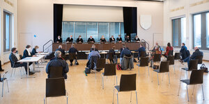 Die Hamburgischen Verrfassungsrichter sitzen nebeneinander im Saal vor den anderen Verfahrensbeteiligten