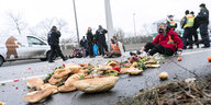 Brötchen und andere Lebensmittel sind auf einer Straße während einer Sitzblockade verstreut, im Hintergrund Polizisten