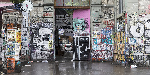 Eingangstür eines mit Plakaten und Graffitis versehenen Hauses