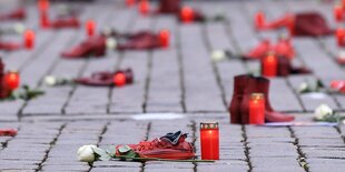 Rote Schuhe und rote Grabkerzen