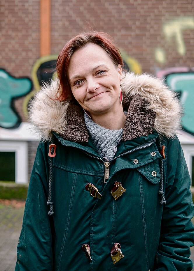 Carina Walter steht vor einer Wand mit Graffiti.