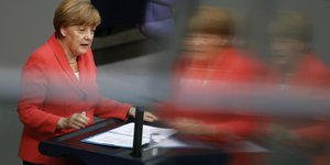 Angela Merkel im Bundestag, ihr Bild wird gespiegelt