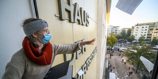 Eine Frau wirft Akten aus einem Fenster