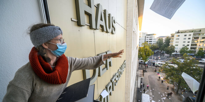 Eine Frau wirft Akten aus einem Fenster