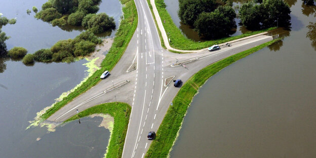 Auf einer teilweise überfluteten Straßenkreuzung bei Hitzacker (Niedersachsen) stehen verschiedene Autos