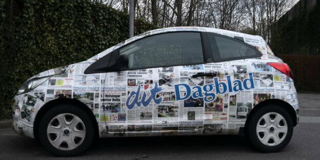 Ein mit Zeitungsseiten bedrucktes Auto.