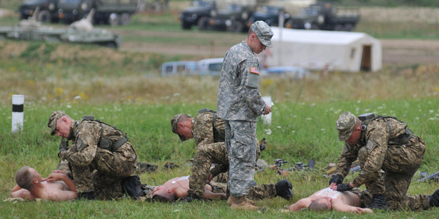 Ein US-Soldat erklärt ukrainischen Soldaten grundsätzliche medizinische Notfallhilfe