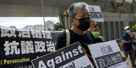 Lee Cheuk-yan mit einem Schild gegen politische Unterdrückung auf einer Demo