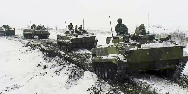 Russische Panzer fahren durch Schnee und Schlamm.