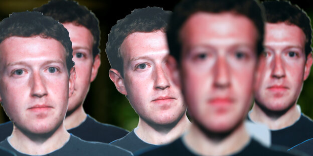 Plakate mit dem Kopf von Mark Zuckerberg bei einer Protestaktion.