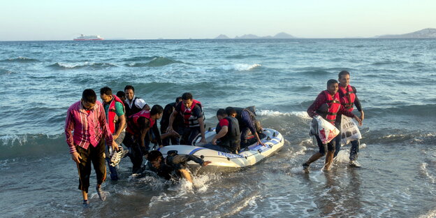 Flüchtlinge steigen aus einem Schlauchboot