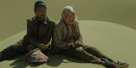 Zwei chinesisch gelesene alte Menschen sitzen nebeneinander