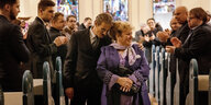 Ein Mann und eine Frau gehen den Mittelgang einer Kirche entlang (keine Hochzeitszeremonie)