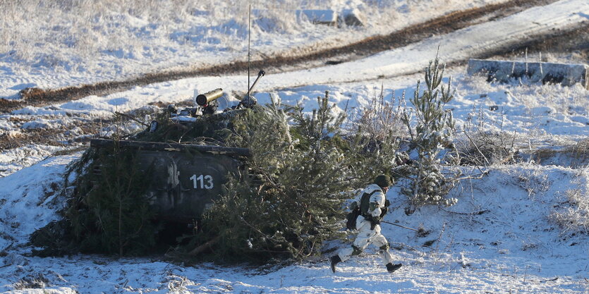 Ein Panzer, der mit Ästen getarnt ist