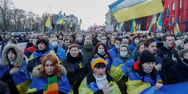 Große Menschenmenge mit ukrainischen Fahnen auf einem Platz