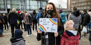 Frau mit Plakat auf Kundgebung