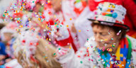 Das Bild zeigt eine Konfetti werfende Karnevalistin.